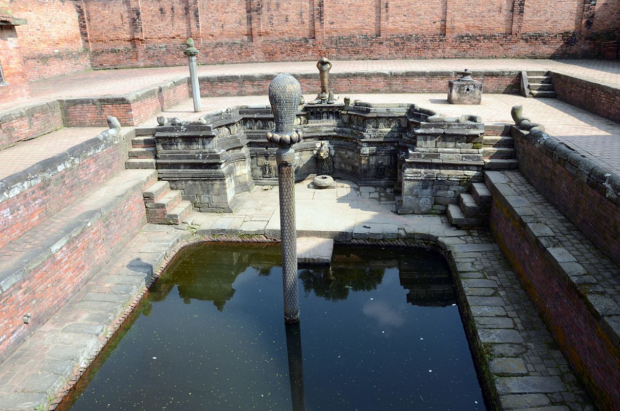 Kathmandu Bhaktapur 05-1 Bhaktapur Durbar Square Naga Pokhari The Naga Pokhari (Snake Pond) in the Palace of 55 Windows in Bhaktapur�s Durbar Square is a 17C royal water tank encircled by a writhing stone cobra. The nagas rise up on scaled pillars.